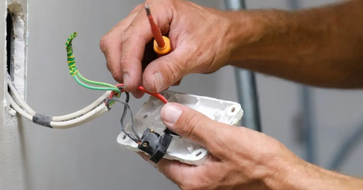 an electrician working on a light switch at client's house
