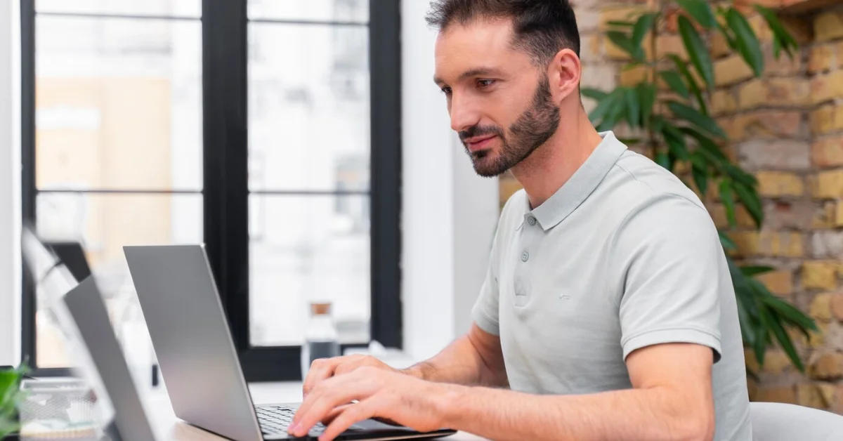 adult man in office using laptop