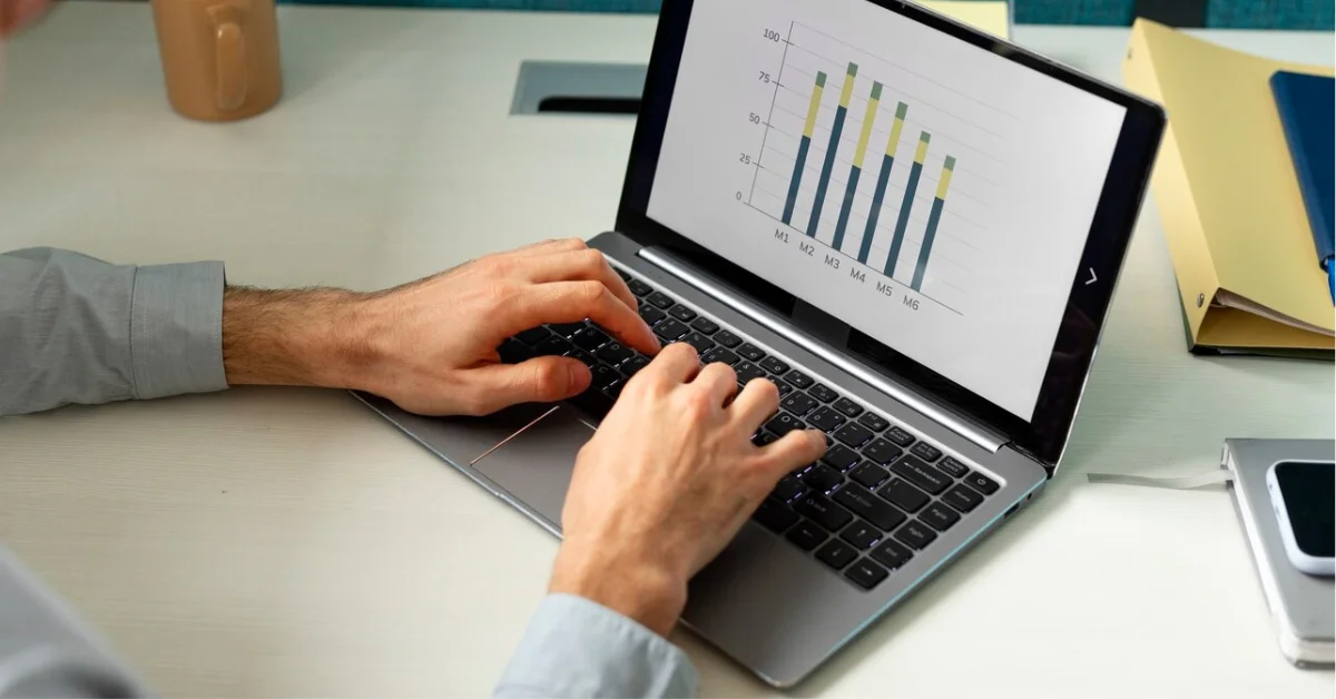 man using laptop with bar chats on screen