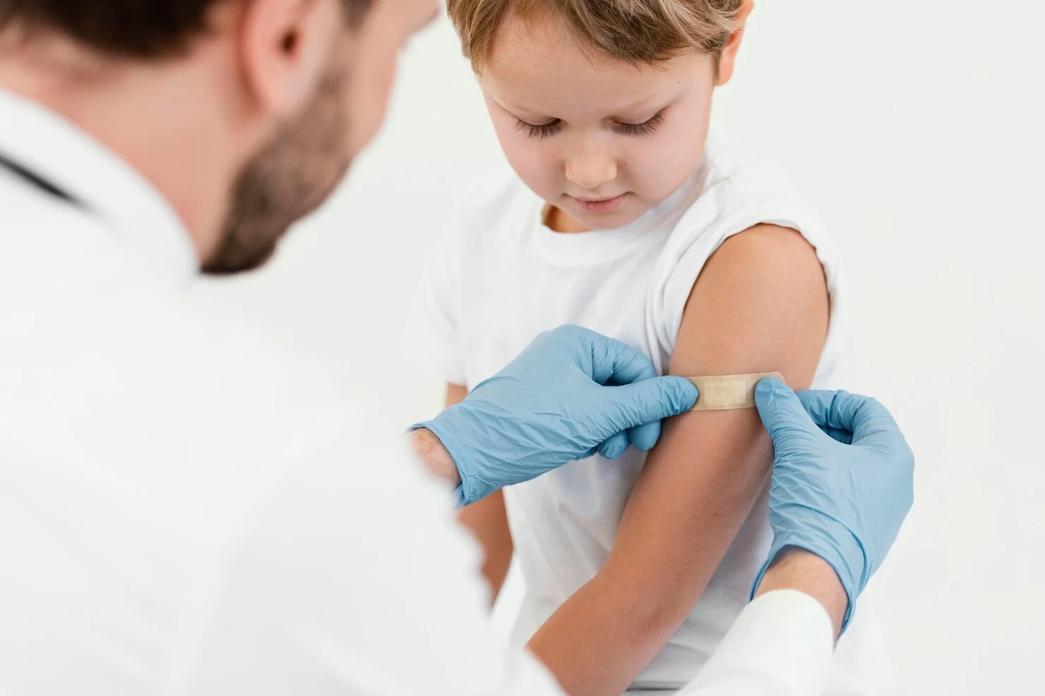 a doctor applying patch on a child's arm
