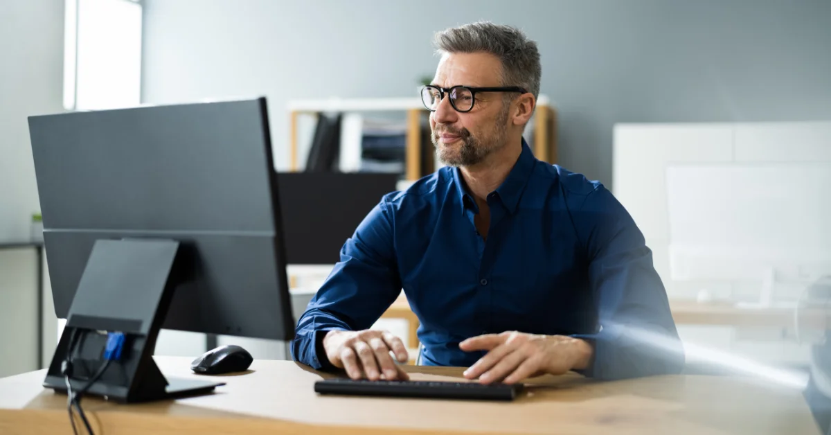 a man using computer wearing a black glasses