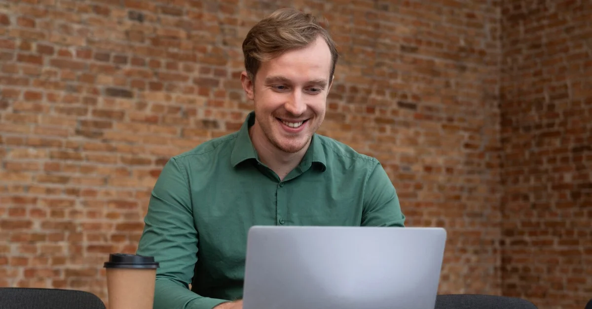 a man smiling and working in an office