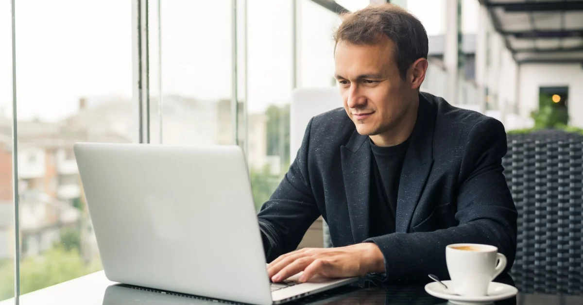 a smiling man using laptop